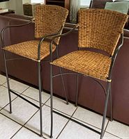 Front view of both wicker and metal bar stools