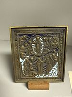 Front view of cast bronze and enamel icon showing Ascension scene and border detail