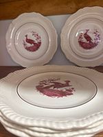 Stacked view of plates showing bird motif centers and scalloped rims