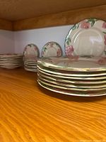 Stacks of dinner plates in foreground, smaller plate stacks behind