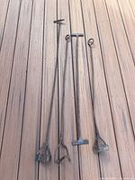 Four iron branding irons laid out showing full length and head shapes