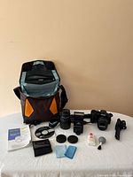 Group shot of all items laid out including camera, lenses, flash, bag, tripod, accessories