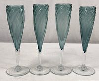 Front view of four matching teal swirl champagne flutes