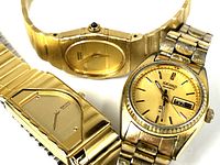 Three Seiko gold-tone wristwatches grouped together