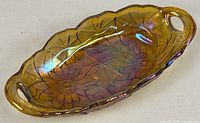 Top view of amber carnival glass oval dish showing sunflower pattern