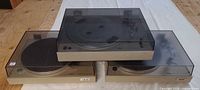 Three AKAI turntables with dust covers in place