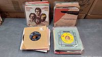Stacked piles of 45 RPM records with various picture and company sleeves