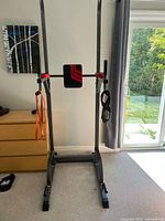 Front view of power tower showing pull-up bar, back pad, arm rests, resistance bands