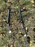 Two Delta matte black faucets with attached hoses laid on grass