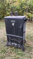 front view of black Dyna-Glo vertical smoker showing gauge, doors and knobs