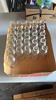 Top view of box containing 26 clear glass bottles