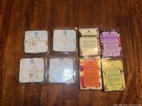 Eight wax melt packages arrayed on wood surface