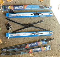 Four packaged wiper blades: top Michelin Stealth, two middle Certified boxed, bottom Michelin Stealth; loose adapters visible