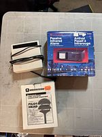 Group shot showing all three boxed items: Safe House alarm box, Merrcyro light box, Eveready device