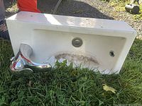 Front view of white ceramic sink showing faucet, drain, and overflow