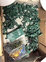 box containing numerous green army men figures and green tank body