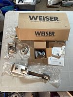Boxed Weiser handleset components spread on table