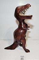 Full left-side view of carved mahogany Tyrannosaurus Rex showing overall form