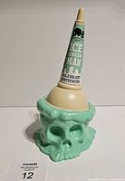 Front view of vinyl figure showing skull base and cone