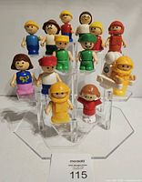 All fourteen Playskool Lil Playmates figures displayed on acrylic risers