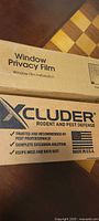 Boxed Coavas Window Privacy Film and boxed Xcluder Door Sweep visible