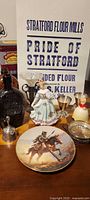 Group view of entire lot showing bottles, plate, figurine, flour bag, bells, goblets