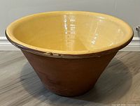 Overall view of terracotta pancheon bowl showing yellow glazed interior and rim