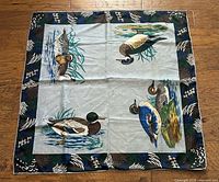 Full view of square silk scarf showing duck illustrations and feather border