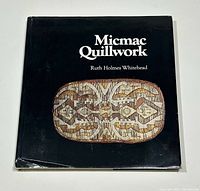 Front of book with dust jacket showing title and quillwork image