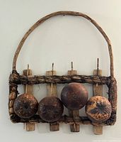 Full view of wall hanging showing frame, handle and coconut shells