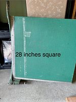 Front view showing 28 in square cutting surface with grid, side ruler, and cutting arm