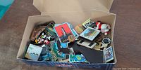 Open box showing variety of destination magnets, Disney magnet, plush figure