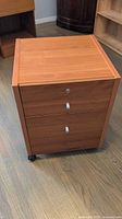 Full front view of mobile pedestal filing cabinet showing finish, pulls, lock and casters