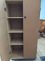 Cabinet door open showing four interior shelves and particle board construction