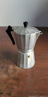 Side view of moka pot showing body, handle and valve