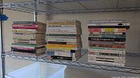 Three stacks of vintage paperbacks on wire shelf