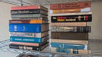 Two stacks of vintage hardcover books on wire shelf