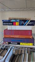 Stack of ten Russian language books on wire shelf
