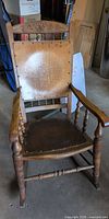 Full view of pressed-back rocking chair showing overall design, arms, seat, legs and rockers