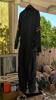 Full view of hanging navy jumpsuit showing overall design and length