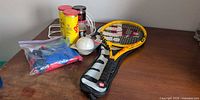Lot overview showing racquet, ball cans, softball, grips