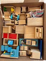 box showing variety of wooden dollhouse furniture pieces