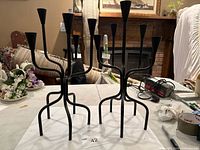 Both black five-arm candlesticks front view on table