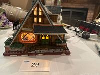 Front view of Chalet Café building lit, showing main façade and dimensions tag