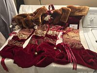 Four red velvet stockings with faux fur cuffs displayed on surface