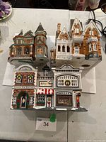 All three ceramic Christmas village buildings grouped on table