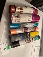 Seven vinyl rolls laid out, showing brands, colors and packaging