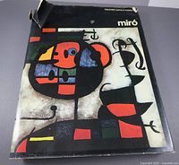 Front of dust-jacketed book showing title and Miró artwork; visible tear at top edge