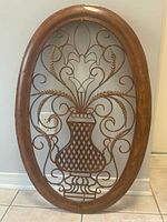 Full view of oval metal wall hanging showing entire design