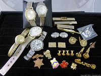 Full lot overview showing watches, tie clips, cufflinks, pins